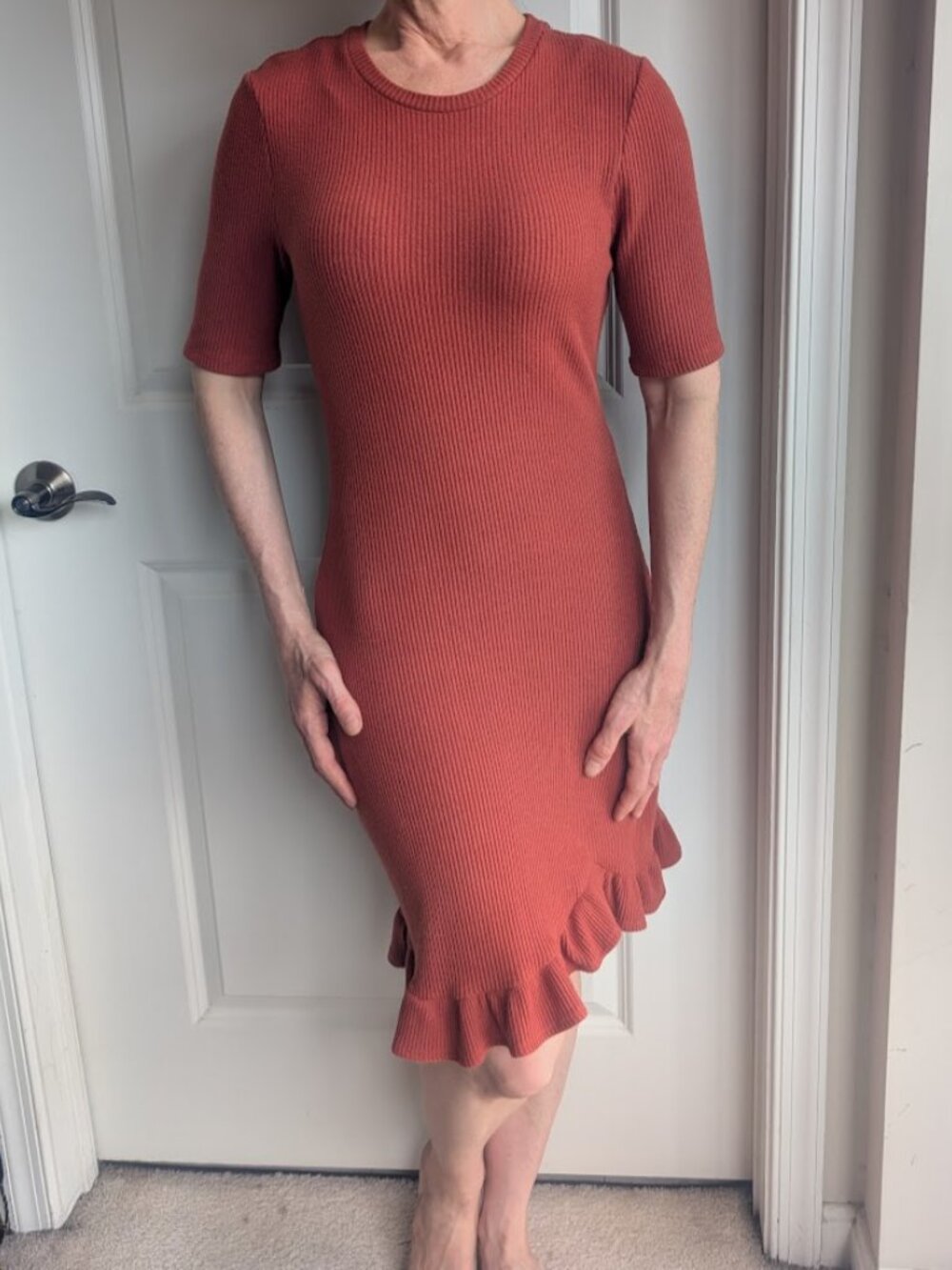 Flattering rust-orange stretchy-knit dress with ruffle hemline. By Le Lis.
